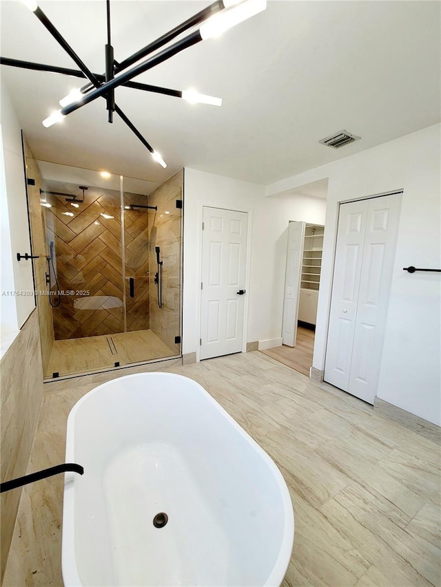 bathroom featuring visible vents, a shower stall, baseboards, a closet, and a soaking tub