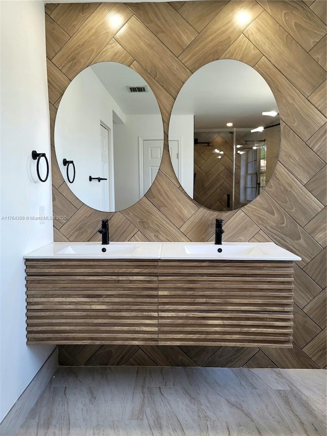 bathroom featuring double vanity, visible vents, and a sink