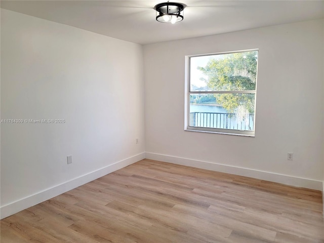 unfurnished room featuring baseboards and light wood-type flooring