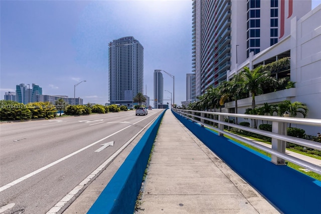 view of street featuring a city view, street lights, and sidewalks