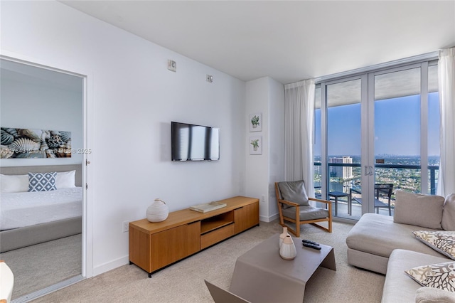 living room with floor to ceiling windows, light colored carpet, and baseboards