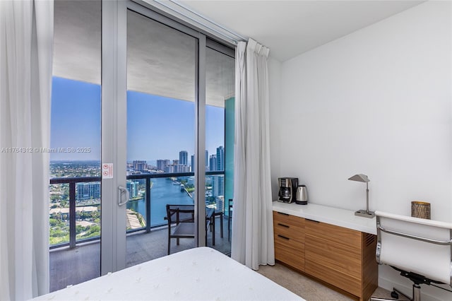 bedroom featuring a city view, a wall of windows, and french doors