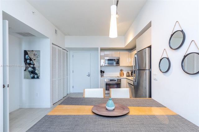 dining area with visible vents and light wood-type flooring