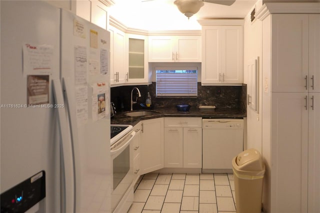 kitchen with backsplash, glass insert cabinets, white cabinets, white appliances, and a sink