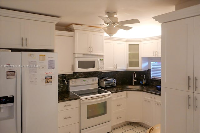 kitchen featuring backsplash, a toaster, white cabinets, white appliances, and a sink