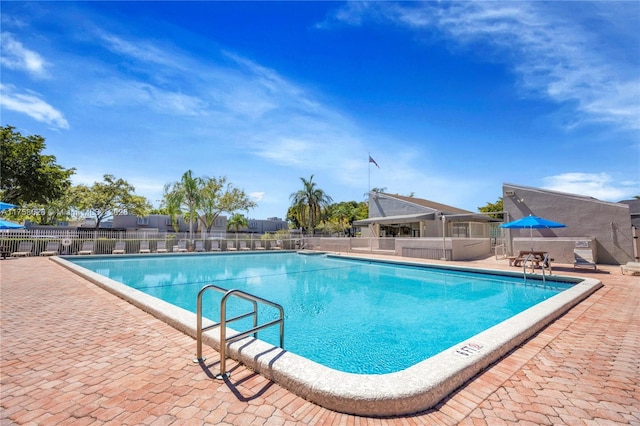 pool with a patio and fence