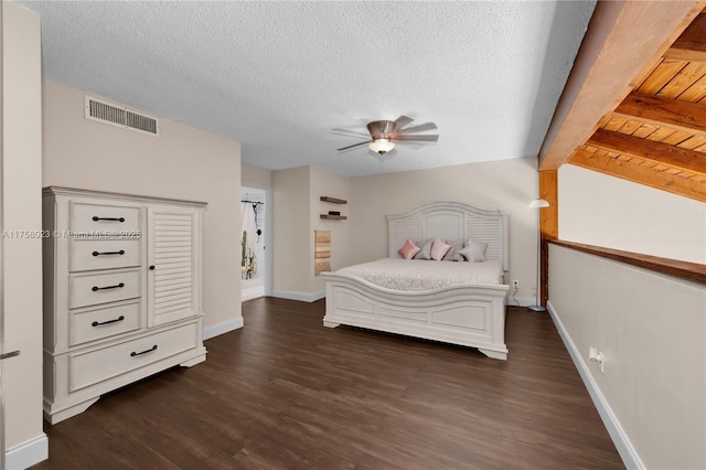 bedroom featuring dark wood finished floors, visible vents, and a textured ceiling