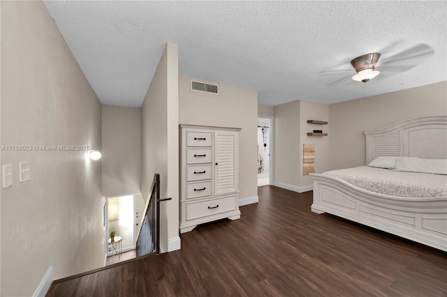 bedroom featuring baseboards, visible vents, dark wood finished floors, ceiling fan, and a textured ceiling