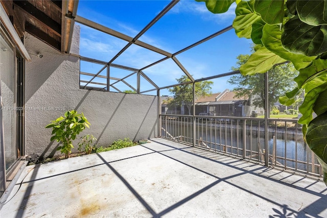 exterior space featuring glass enclosure and a water view