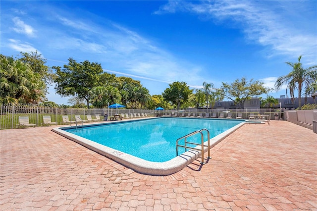 pool with a patio area and fence