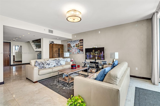 living room featuring visible vents, marble finish floor, wallpapered walls, baseboards, and an accent wall