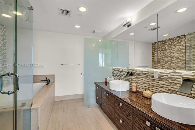 bathroom featuring tasteful backsplash, visible vents, and a sink