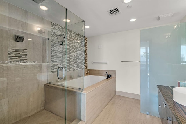 bathroom with vanity, visible vents, recessed lighting, a shower stall, and a garden tub