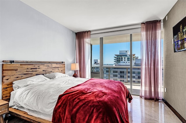 bedroom with access to exterior, floor to ceiling windows, and baseboards