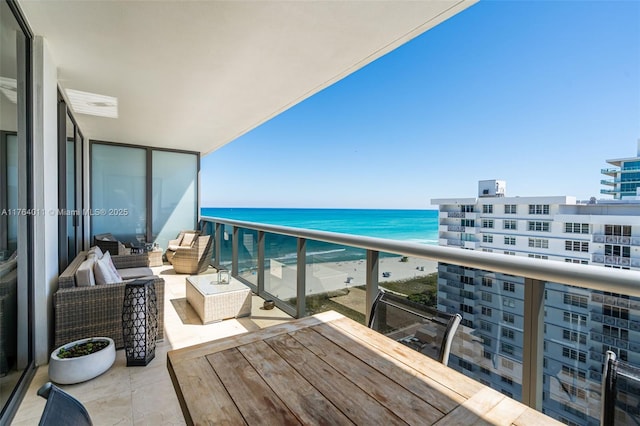 balcony with an outdoor living space and a water view