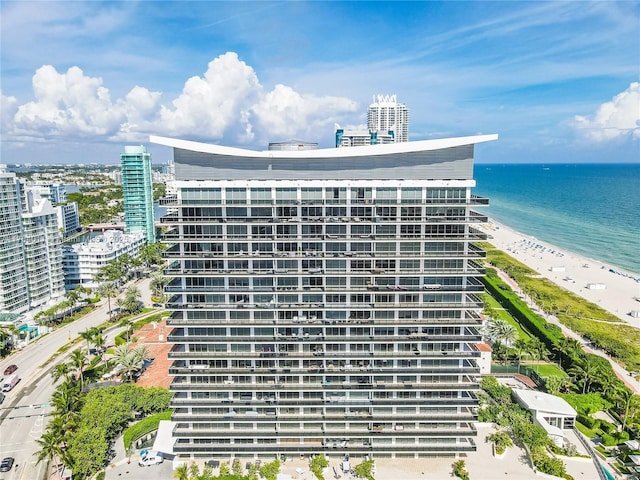 view of building exterior featuring a city view, a beach view, and a water view