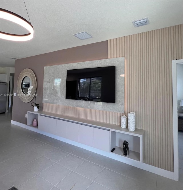 room details with visible vents, wallpapered walls, a textured ceiling, and fridge