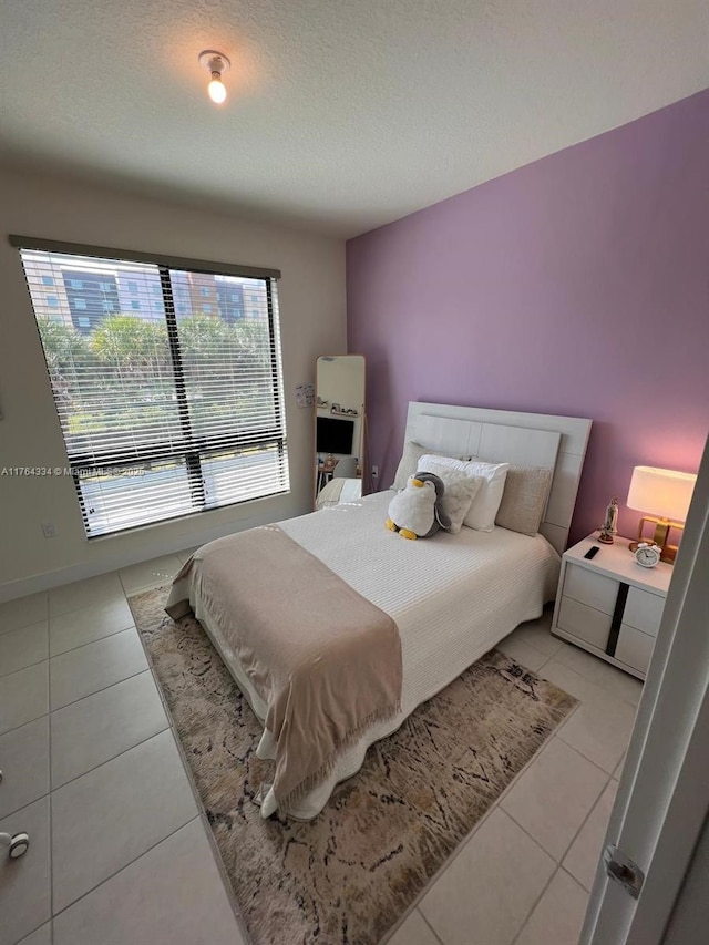 bedroom with light tile patterned floors and a textured ceiling