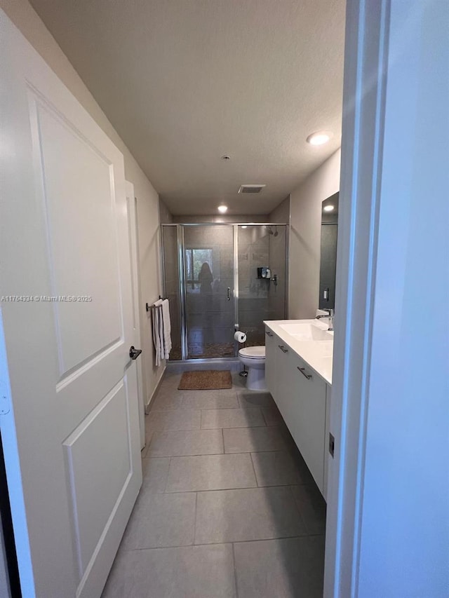 full bath with visible vents, a shower stall, toilet, tile patterned floors, and vanity