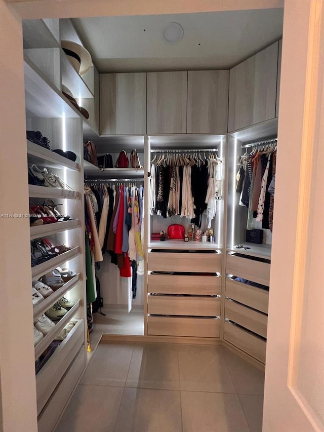 walk in closet with light tile patterned floors