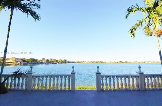 view of dock with fence and a water view