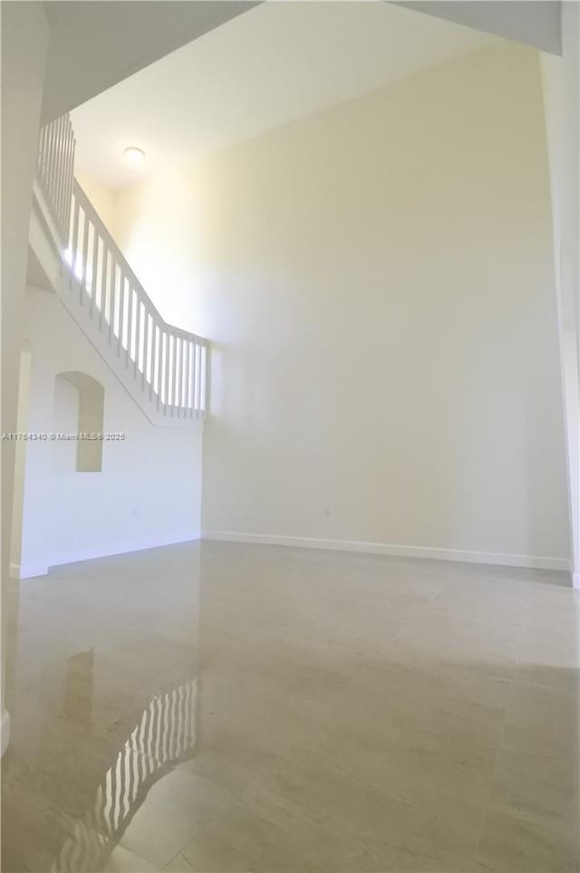 interior space featuring baseboards and a towering ceiling