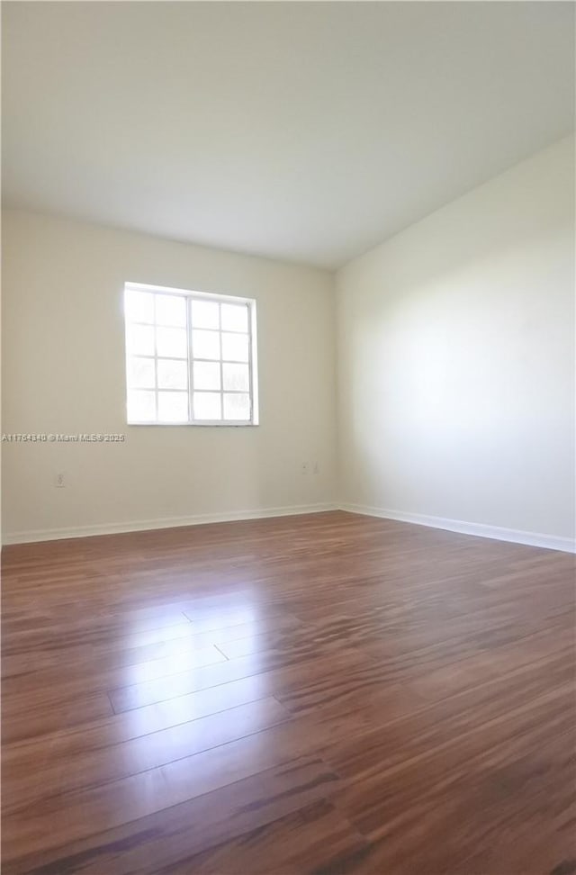 unfurnished room featuring dark wood finished floors and baseboards