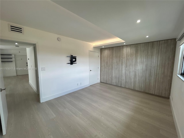 unfurnished room featuring recessed lighting, visible vents, light wood-type flooring, and baseboards