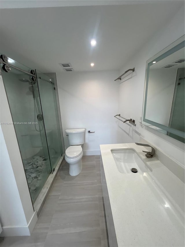full bathroom with visible vents, baseboards, toilet, vanity, and a stall shower