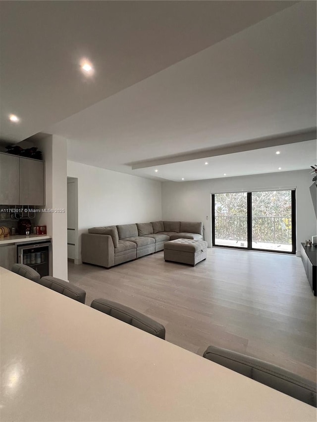 living room with wine cooler, recessed lighting, and light wood-style floors