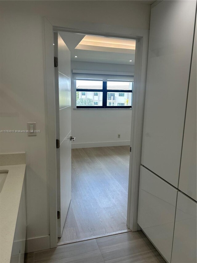 hallway with baseboards and wood finished floors