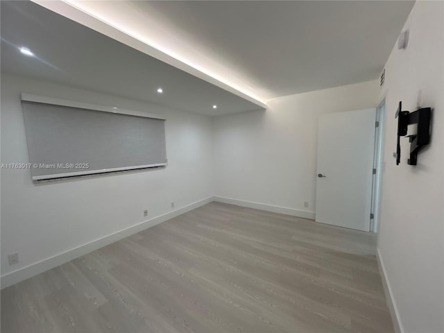 spare room featuring light wood-type flooring, baseboards, visible vents, and recessed lighting
