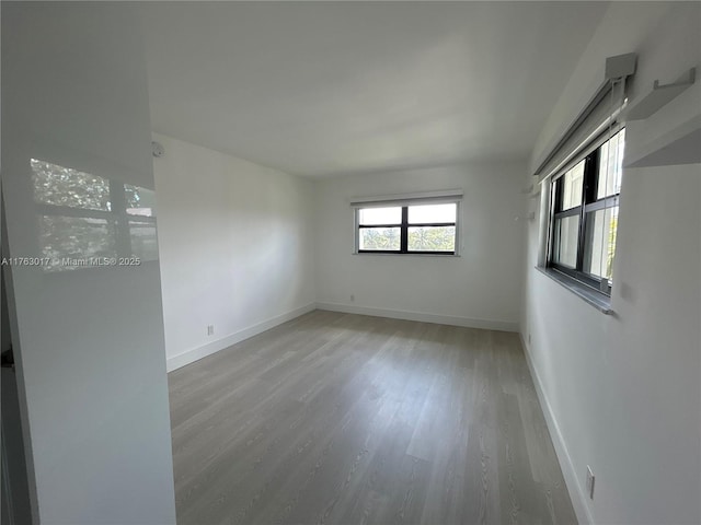 spare room with light wood-style flooring and baseboards
