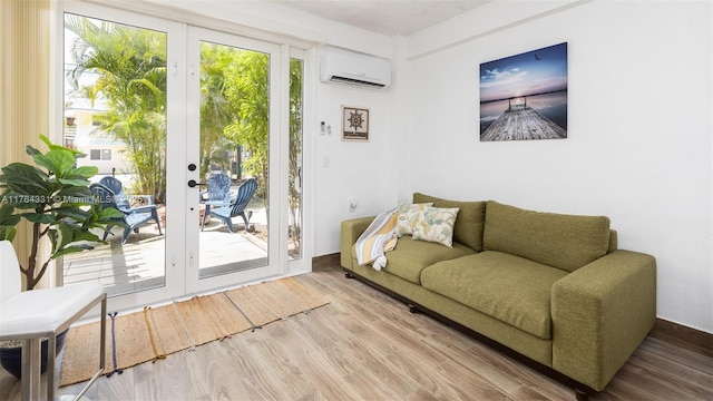 living area with a wall unit AC, french doors, wood finished floors, and a wealth of natural light