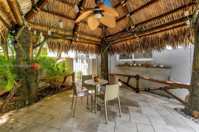 view of patio with a gazebo, outdoor dining space, and a ceiling fan