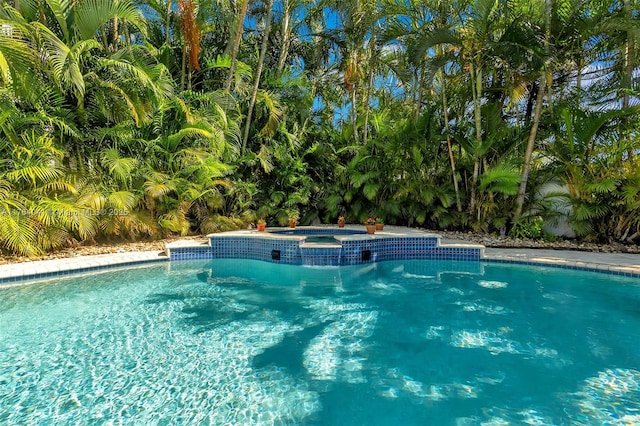 outdoor pool featuring an in ground hot tub