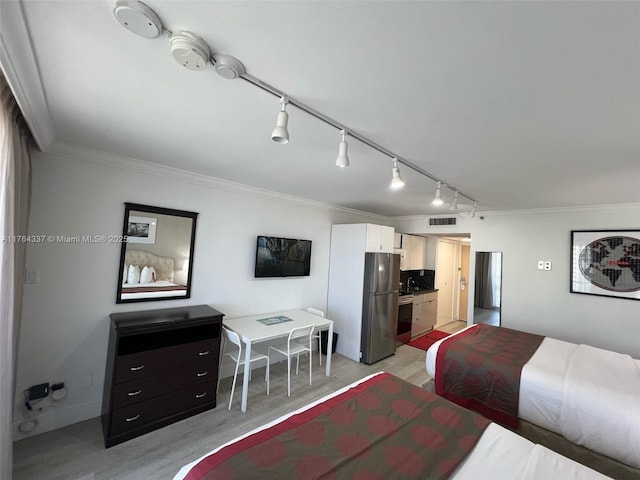 bedroom with baseboards, visible vents, freestanding refrigerator, and ornamental molding