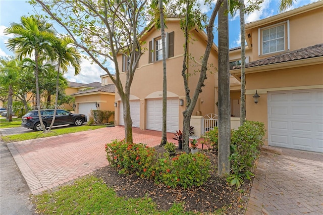 view of front of property featuring stucco siding, an attached garage, and driveway