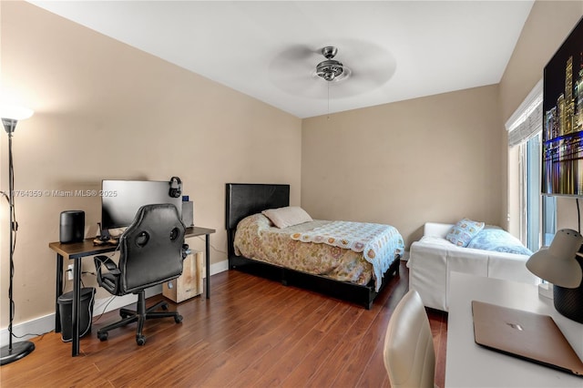 bedroom with ceiling fan, baseboards, and wood finished floors