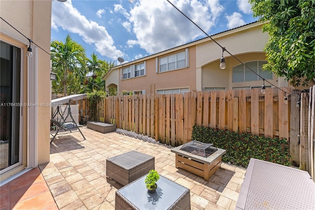 view of patio featuring a fire pit and fence