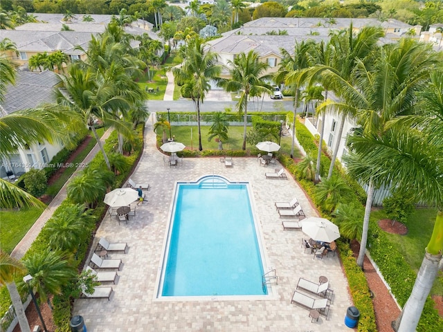 community pool with a patio area, a yard, and fence