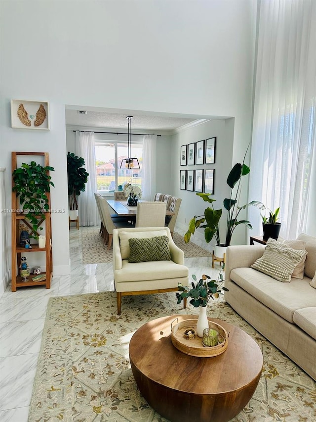 living room featuring baseboards, a high ceiling, and marble finish floor