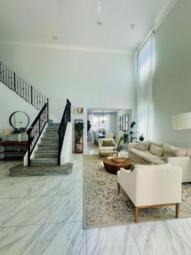 living room with stairway, marble finish floor, a towering ceiling, and crown molding