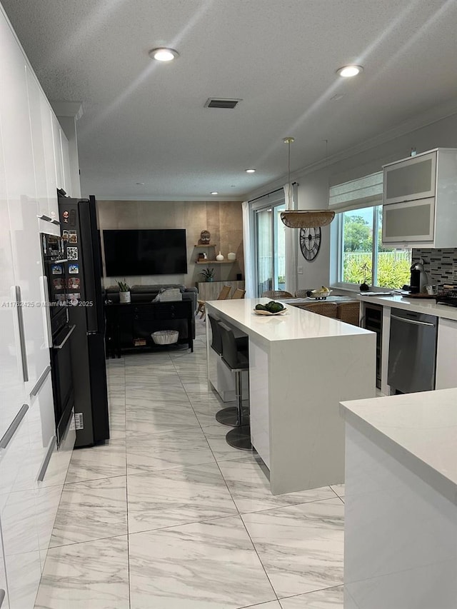 kitchen with visible vents, white cabinets, light countertops, and stainless steel dishwasher