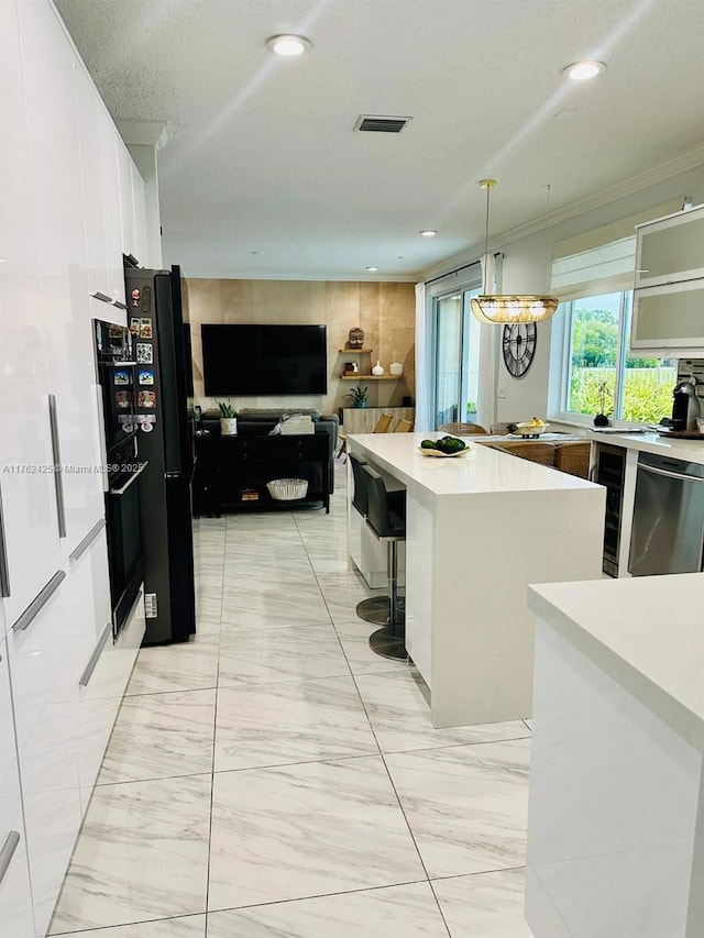 kitchen featuring marble finish floor, black appliances, a kitchen island, white cabinetry, and light countertops