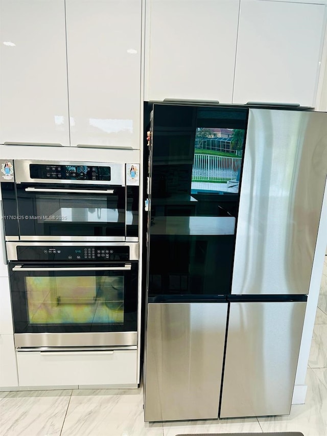 kitchen featuring multiple ovens, smart refrigerator, white cabinets, modern cabinets, and marble finish floor