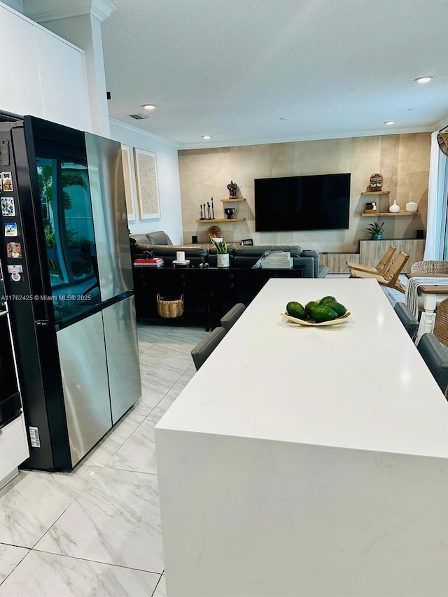 kitchen with white cabinets, recessed lighting, marble finish floor, and freestanding refrigerator