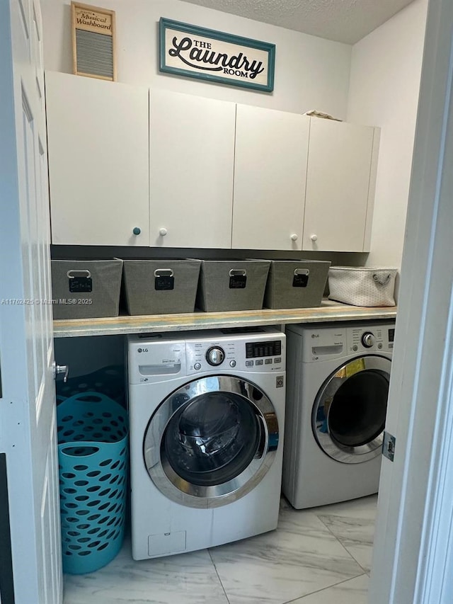 washroom featuring cabinet space, marble finish floor, independent washer and dryer, and a textured ceiling