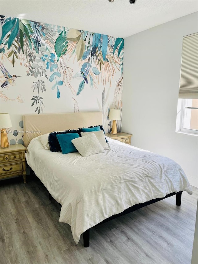 bedroom featuring wood finished floors and a textured ceiling