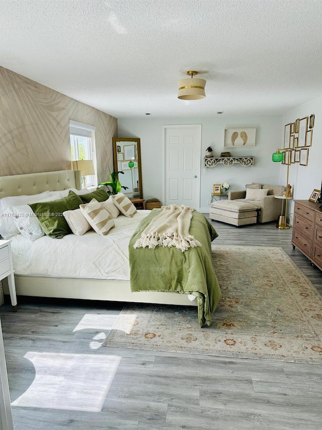 bedroom featuring wood finished floors and a textured ceiling